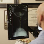 Chiropractor reviewing neck and back symptoms with a patient after a car accident in a modern clinic. auto accident chiropractor