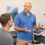 Doctor Jarred explains Class 4 laser therapy to an adult patient in a Fishers chiropractic treatment room., what is class 4 laser therapy, class IV laser therapy, Class 4 laser treatment, medical laser therapy,